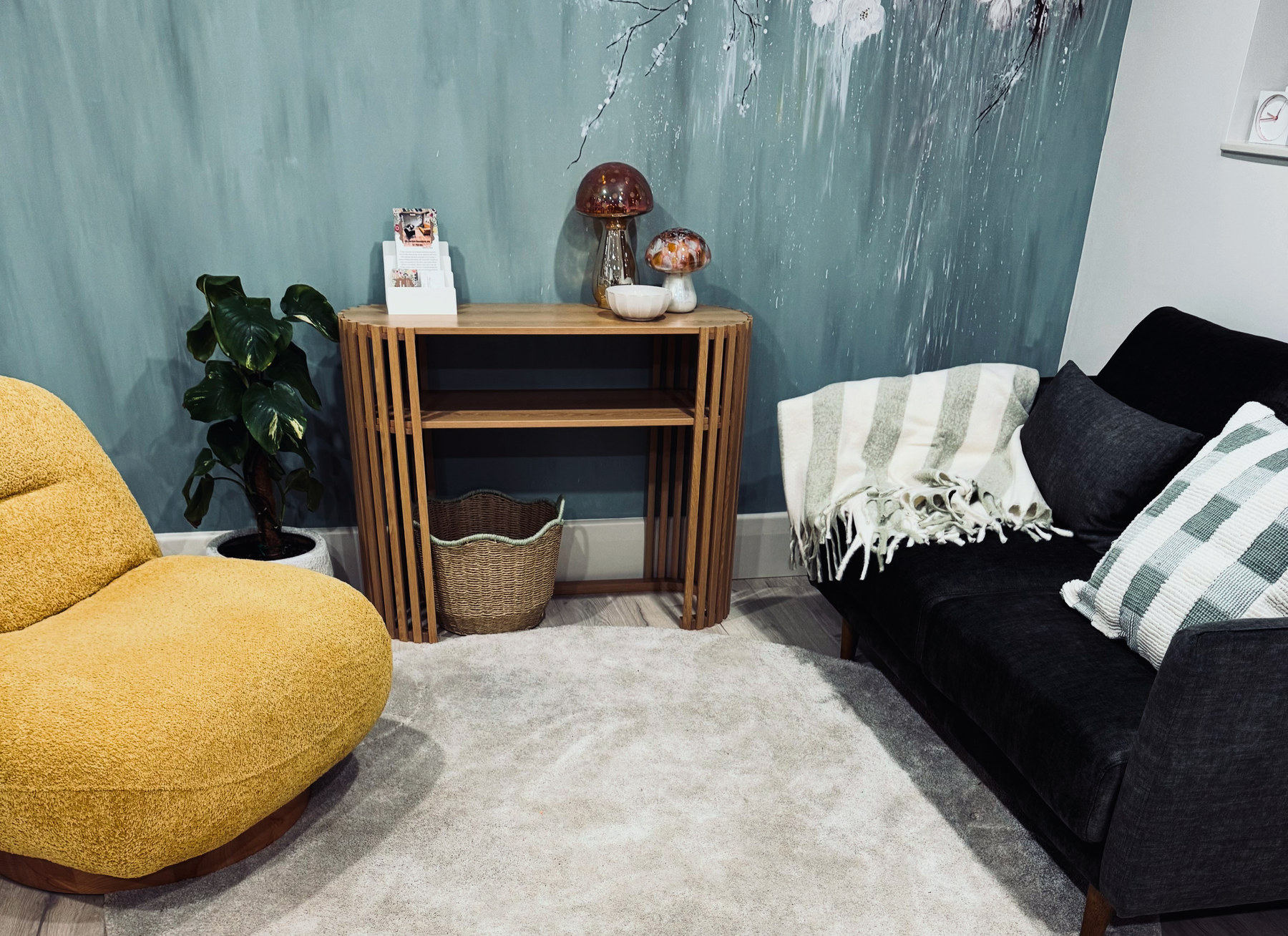 The therapy room in Stirling: soft chairs, warm lamps and a calm sage wall